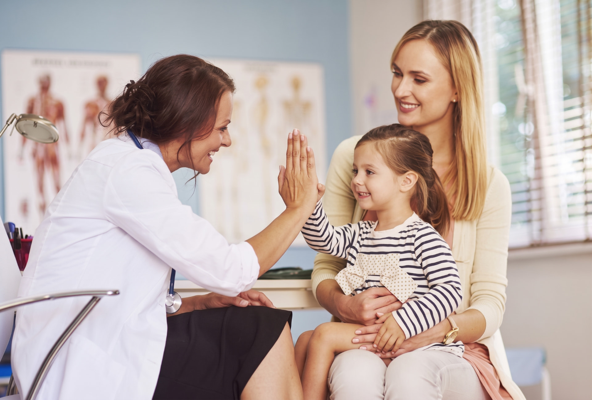 Pediatrician greeting a child with her mother